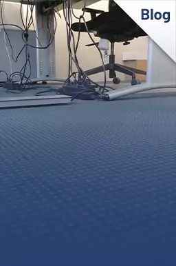 Loshangende kabels onder een bureau. 